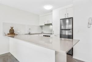 穆卢拉巴斯皮特海浪拍岸酒店的厨房配有白色橱柜和冰箱。