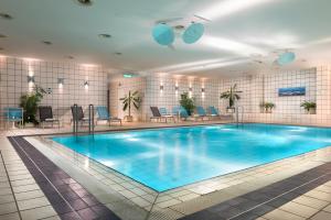 柏林柏林城西假日酒店的酒店的大型游泳池配有桌椅