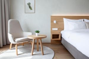 布拉格Botanique Hotel Prague的一间卧室配有一张床、一把椅子和一张桌子