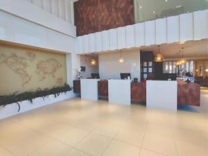 沙佩科Mogano Express Hotel - PET FRIENDLY- ELETROPOSTO的一个带前台和柜台的大型大堂