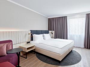 汉堡Crowne Plaza Hamburg-City Alster, an IHG Hotel的酒店客房配有白色的床和沙发。