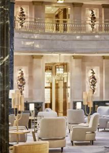 马德里Four Seasons Hotel Madrid的一个带桌椅的大堂和一座建筑