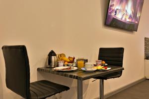 宰斯特Wellness Suite Zeist的一张桌子和两把椅子,上面有食物
