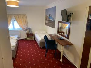 布拉格城市客栈的酒店客房配有书桌、床和镜子