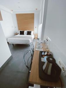 萨拉曼卡Salamanca Suites Libertad的一间卧室配有一张床和一张带台灯的桌子