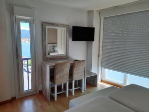 穆罗斯穆拉达纳酒店的一间卧室配有桌椅和电视。