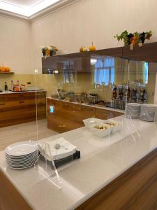 阿巴诺泰尔梅大西洋天然温泉酒店的厨房配有带椅子和盘子的柜台