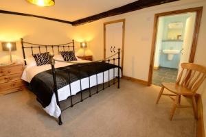 格拉斯米尔Stickle Cottage, Great Langdale的一间卧室配有一张大床和一把椅子