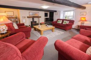 格拉斯米尔Stickle Cottage, Great Langdale的客厅设有红色的沙发和壁炉