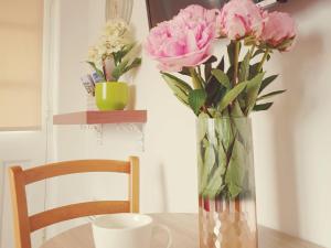 Fen Drayton索恩之家住宿加早餐旅馆的花瓶,花朵粉红色,坐在桌子上