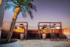 伯迪亚哥Pousada Conca di Mare - Restaurante - Pé na areia com serviço de praia的一个带两座甲板、椅子和棕榈树的度假胜地