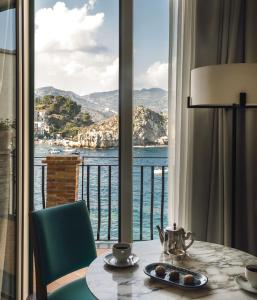 陶尔米纳Villa Sant'Andrea, A Belmond Hotel, Taormina Mare的水景客房 - 带桌子