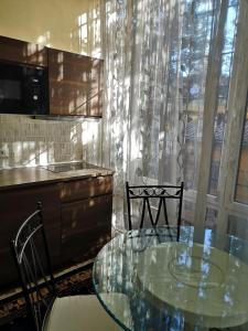 罗马AKIRE的厨房配有玻璃桌和两把椅子
