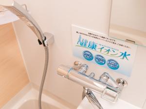 东京池袋站北口乐活超级酒店的带淋浴的浴室和墙上的标志