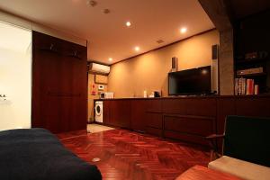东京D工作室酒店的一间卧室配有一张床和一台平面电视