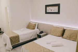 萨利纳斯Hotel Valley Hills的酒店客房设有两张床,墙上挂着一张照片。