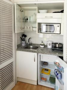 阿德耶维帕莱索公寓 的厨房配有白色橱柜、水槽和微波炉