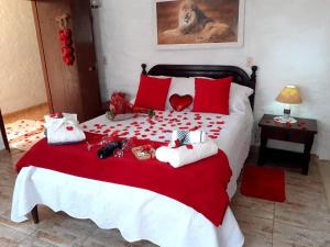 蒙特韦尔迪Chalé pinheiro velho的一张红色和白色的床,上面有动物填充物