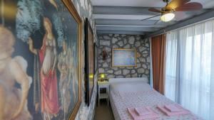 卡拉布伦Teras butik apart的卧室配有一张床,墙上挂有绘画作品