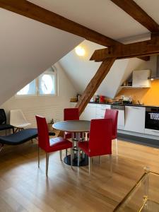 苏黎世Homestay Zurich center的厨房以及带桌子和红色椅子的用餐室。