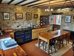 HighamPathways Cottage的厨房配有木桌和蓝色烤箱。