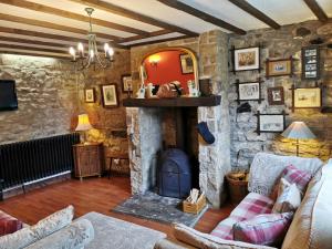 HighamPathways Cottage的客厅设有带壁炉的石墙