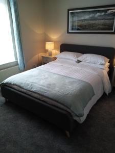 杜林Dubhlinn House的卧室配有一张带白色床单和枕头的大床。