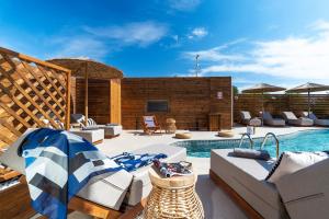 普拉索尼西Oasis Hotel Prasonisi的一个带游泳池、椅子和游泳池的庭院