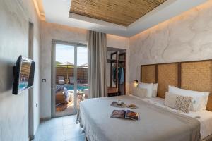 普拉索尼西Oasis Hotel Prasonisi的一间卧室设有一张带电视的床和一个阳台。