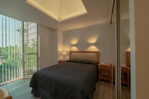 墨西哥城Suites Arquimedes 33的一间卧室设有一张床和一个大窗户