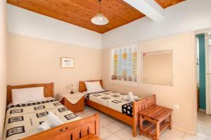 AgrafoíELENI'S TRADITIONAL HOUSE IN AGRAFI的一间卧室设有两张床和窗户。