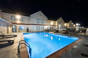 阿比林阿比林贝斯特韦斯特酒店及套房的夜间大型游泳池,灯光照亮