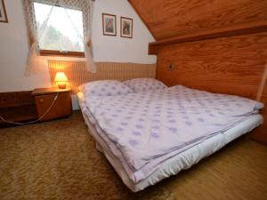 小斯卡拉small holiday home at the edge of the forest的一间带一张大床的卧室,位于带窗户的房间内