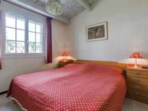 佩梅纳德Modern holiday home with swimming pool的一间卧室设有红色的床和2个窗户。