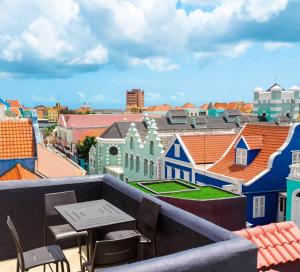 威廉斯塔德Curacao Suites Hotel的阳台享有城市美景,配有桌椅。