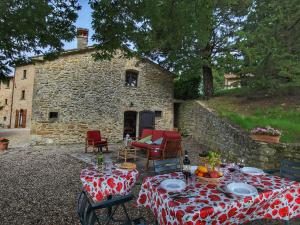 MiscianoCosy Cottage in Anghiari with Pool Garden的石头建筑前的桌椅