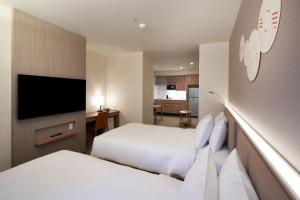 大阪Holiday Inn & Suites Shin Osaka, an IHG Hotel的酒店客房设有两张床和一台平面电视。