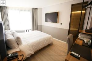 釜山Londoner Hotel Gwangan的酒店客房,配有床和电视