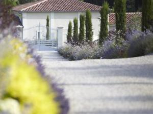 Lussac皮埃尔玫瑰住宿加早餐旅馆的一座种有紫色花卉和白色房子的花园