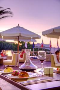阿德里安诺斯坎波斯Solimar Dias Hotel的一张桌子,上面放着食物和一杯葡萄酒