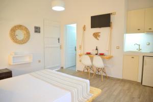 阿达玛斯Margaritari Studios Milos的卧室配有一张床和一张桌子及椅子