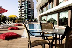 安塔利亚沃尔基酒店的一个带桌椅的庭院和一个游泳池