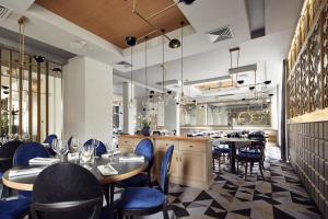 克拉科夫阿派斯酒店的一间带桌椅的餐厅和一间酒吧