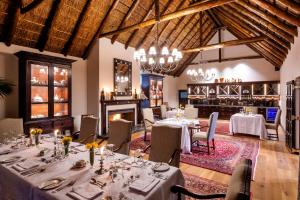 帕特森Lalibela Game Reserve - Kichaka Lodge的一间带桌椅和壁炉的用餐室