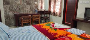 马杜赖Hotel Temple View的一间卧室配有一张带彩色毯子的床