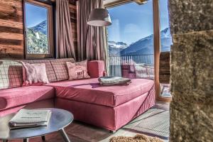 索尔登Chalets - The Peak的客厅配有粉红色的沙发和桌子