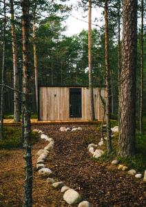 RooslepaÖÖD Hötels Rooslepa - FIKA, MYSA , SKÖNT-with sauna的森林中树木的建筑物