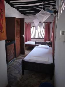 迪亚尼海滩迪亚尼班达旅馆的一间带床的卧室,位于带窗户的房间内