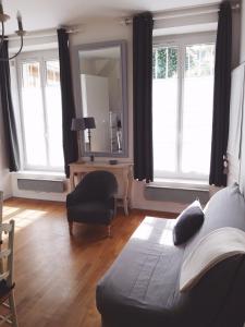 凡尔赛小芒萨尔公寓的客厅配有沙发、椅子和镜子