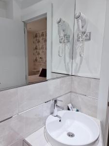 马德里马德里见旅馆的浴室设有白色水槽和镜子